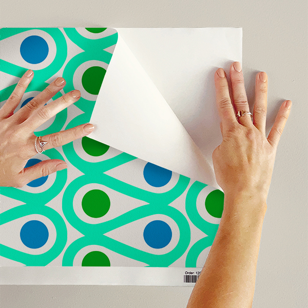 The artwork features a repetitive geometric pattern with curved, teal shapes creating loops that flow in symmetrical vertical columns. Inside the loops, there are solid circular shapes alternating between green and blue, with green circles in the left column and blue circles in the right column. The white background accentuates the vivid colors and clean lines of the design. The overall composition is balanced with a modern, vibrant aesthetic.